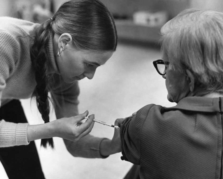 administering vaccines to an older lady 